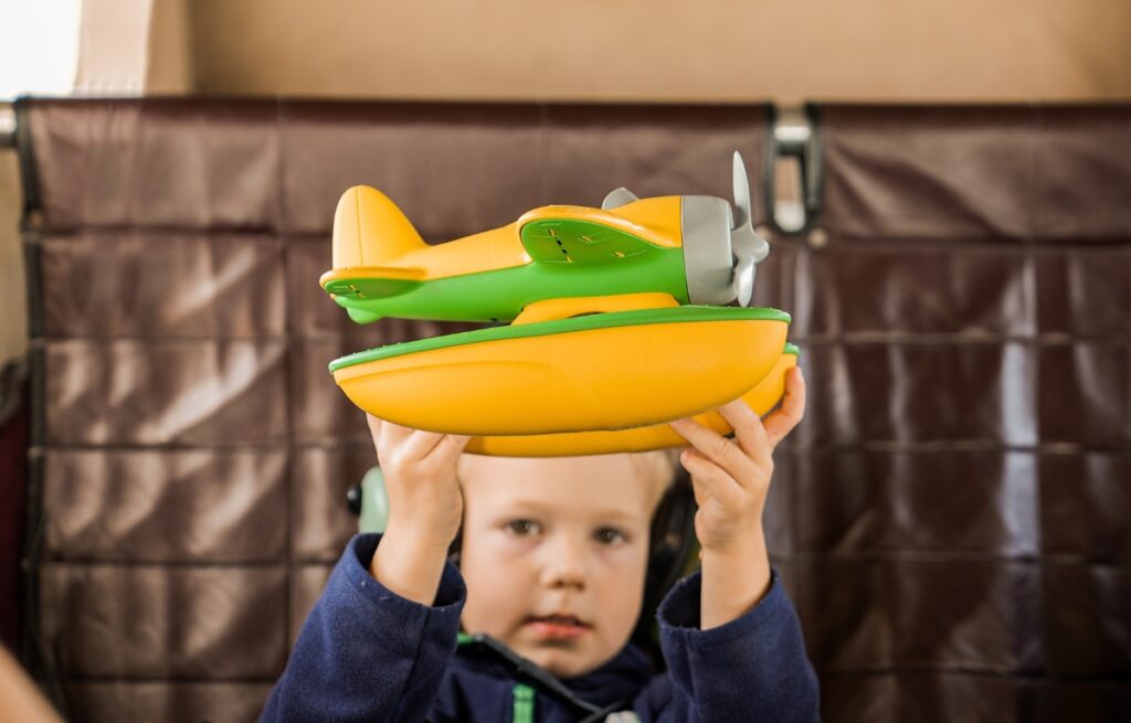 a little boy holding a seaplane toy