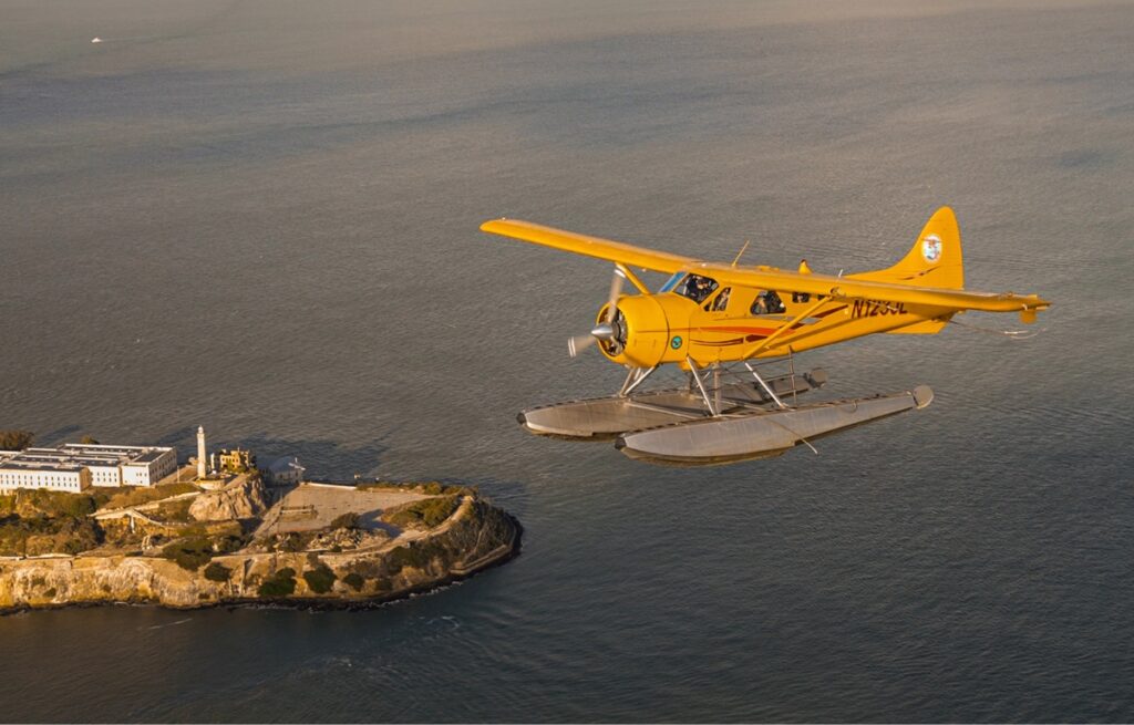 A seaplane flies over Alcatraz